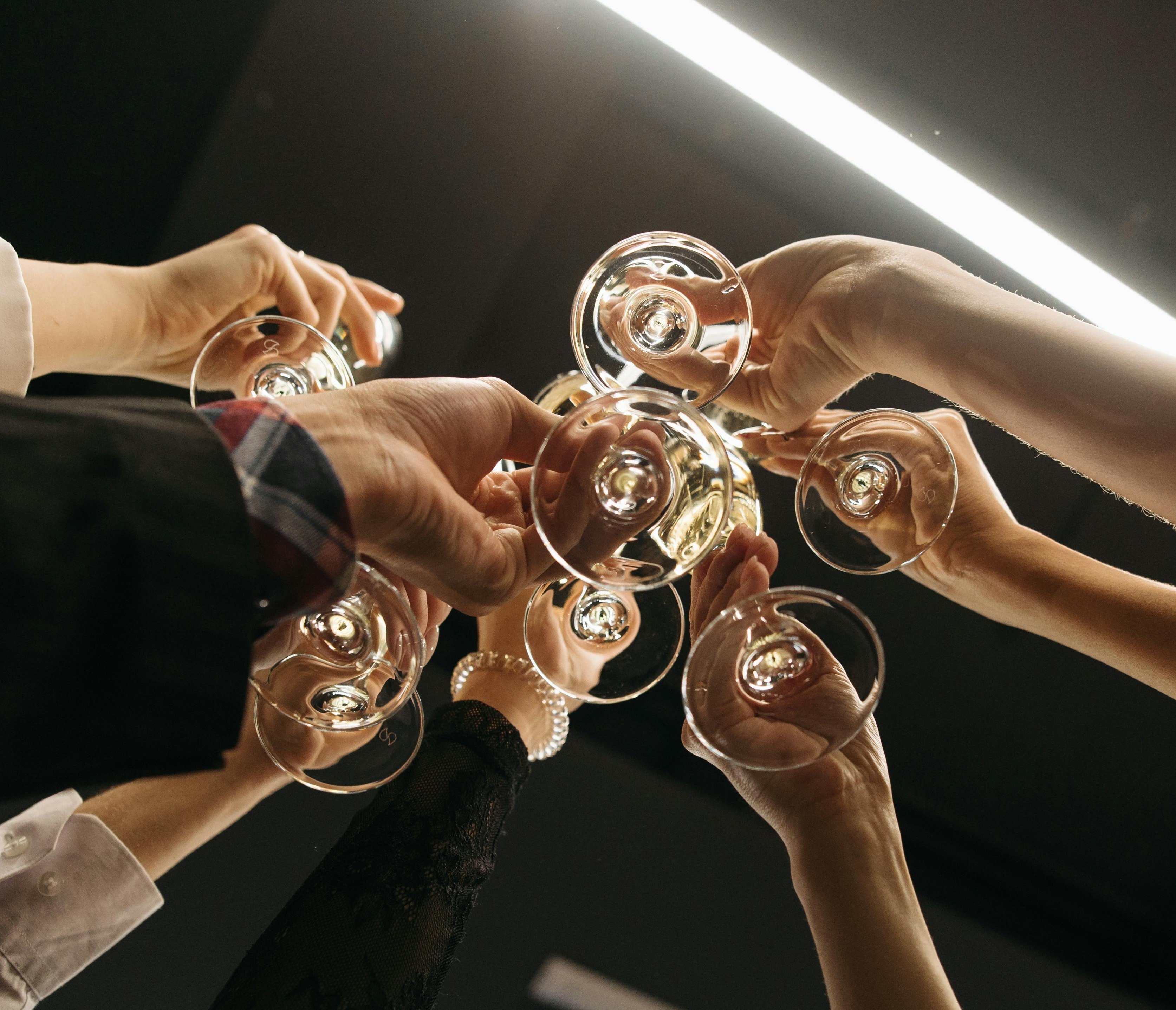 Menschen prosten sich mit Gläsern zu