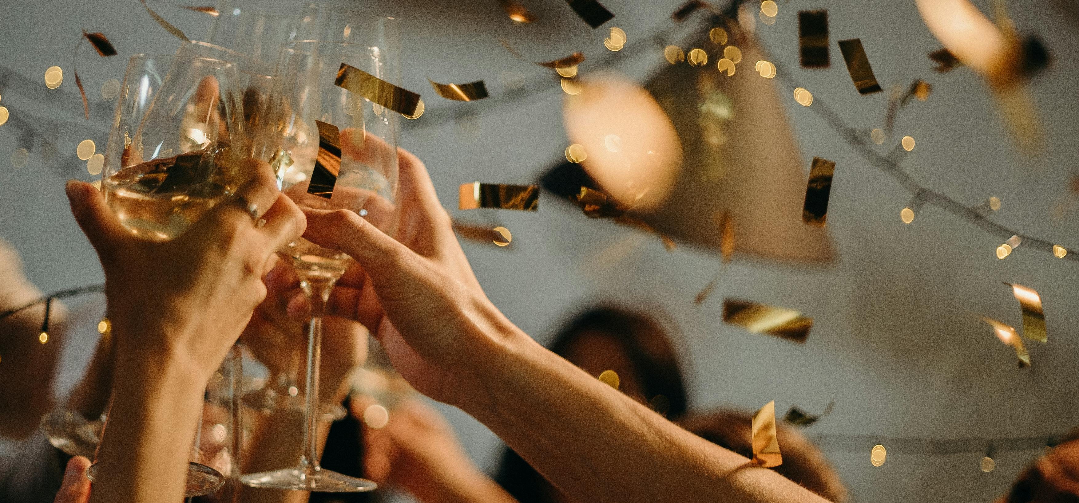 Menschen prosten sich mit Gläsern zu